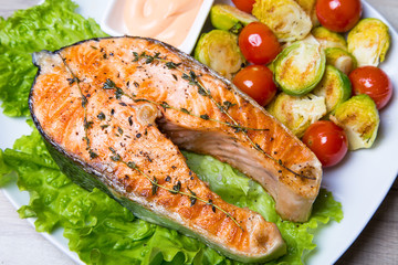 Grilled salmon with brussels sprouts and tomatoes. Close-up, selective focus.