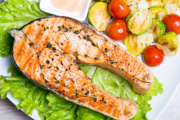 Grilled salmon with brussels sprouts and tomatoes. Close-up, selective focus.