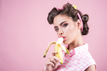 banana dieting. pin up woman with trendy makeup. pinup girl with fashion hair. retro woman eating banana. pretty girl in vintage style, copy space. Selling health © Volodymyr