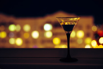 martini on the background of the night city. Bokeh