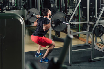 Strong man in the gym doing squats