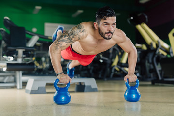 Strong man in the gym doing pushups