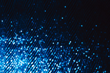 Diagonal of blue sparkling gradient on black background. Holiday concept. Blurred motion.