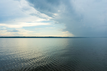 A big river flows under big clouds.