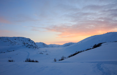 Fire orange and red with yellow colors of sunset evening sky with clouds and mountains on horizon background, picturesque landscape cover wallpaper, sun light beautiful time, snowy hills at winter