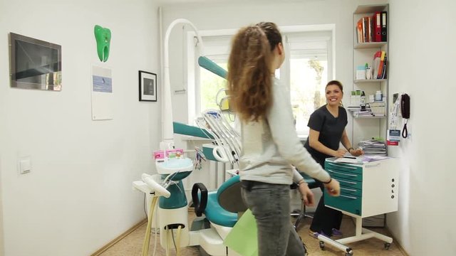 Young daughter come to mother hug kiss in in dental clinic family female girl hair woman affection caucasian child fun hug little love meet smile attractive