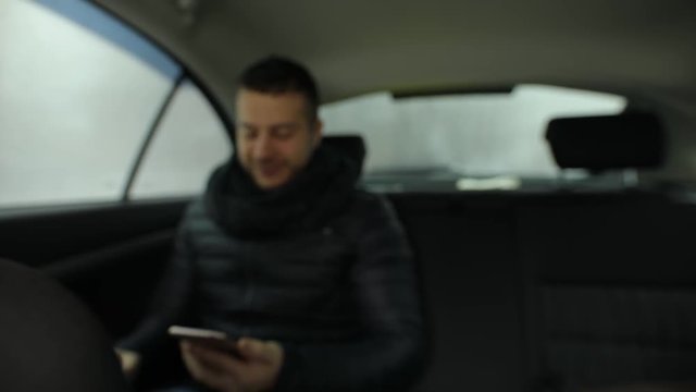 Man demonstrating empty green screen of smartphone in car salon, chroma key