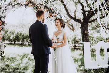 Two lovers hearts on the wedding ceremony. Bride and groom near arch