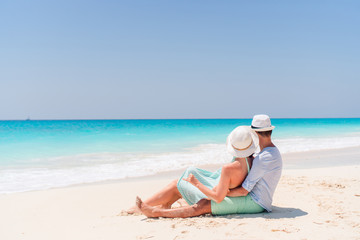 Young couple on white beach during summer vacation. Happy lovers enjoy their honeymoon