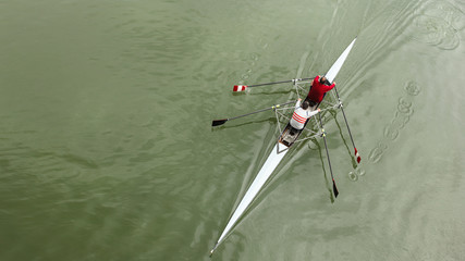Two middle-aged man in a sports boat, rowing on the river