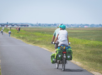 Two persons cycling on tandem bicycle in nature on eurovelo route