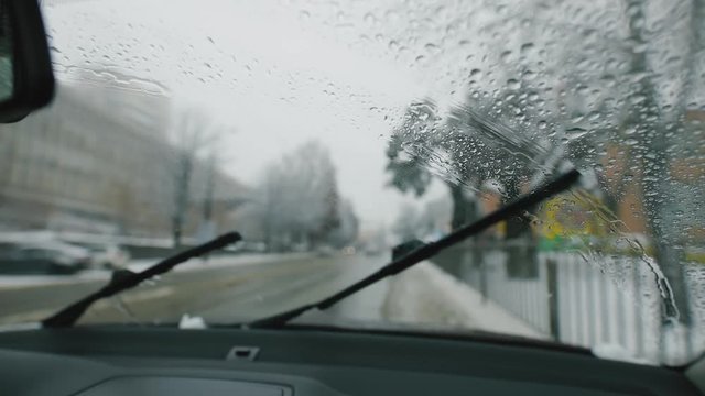 Windshield wipers claaning car window at winter