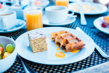 Fresh fruit salad, waffles, cake, coffee and juice served for breakfast at resort restaurant