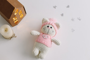 Handmade knitted toy cat on white. Hello kitty. flat lay, top view