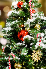 Picture of Christmas tree with red balls, caramel canes, gift, golden snowflakes /