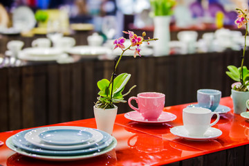 Tea set, porcelain mugs of different colors, decorated table for tea drinking