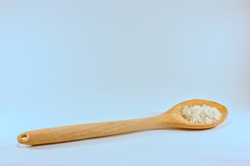 a wooden spoon with some rice grains isolated on white with some copyspace