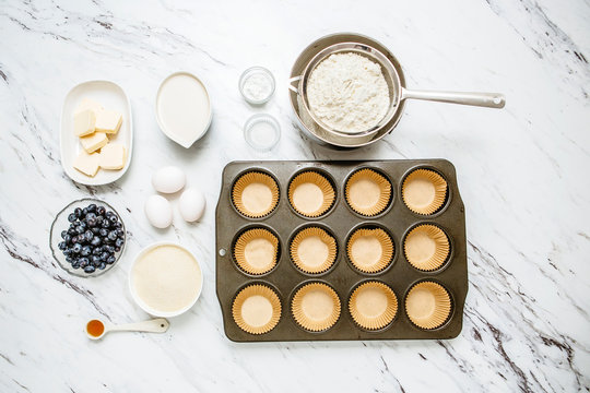 Blueberry Muffin Ingredients, mise en place, on white and gray marble countertop