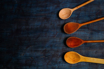 Wooden spoons on vintage blue background with space for text