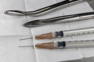 Fototapeta premium Sterile swab, pliers and a medical syringe on a hospital table. Accessories in the doctor's office.