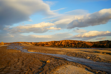 Mud flowing from muddy volcano with beautiful sunset in the background