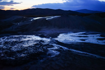 Mud flowing from muddy volcano at night, Berca, Buzau, Romania.