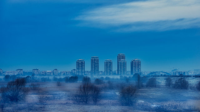 Vacaresti lake and delta natural park, morning foggy landscape with city residentials in background.
