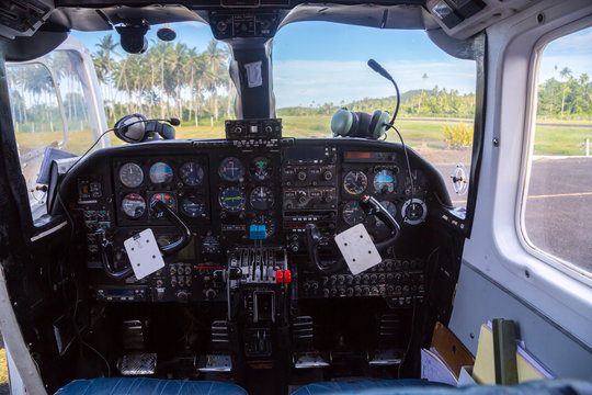 Air travel in Fiji, Melanesia, Oceania. View from a flight deck cockpit window of a small airplane to a remote airstrip overgrown with palms, lost in jungle Levuka town, Ovalau island, near Viti Levu.