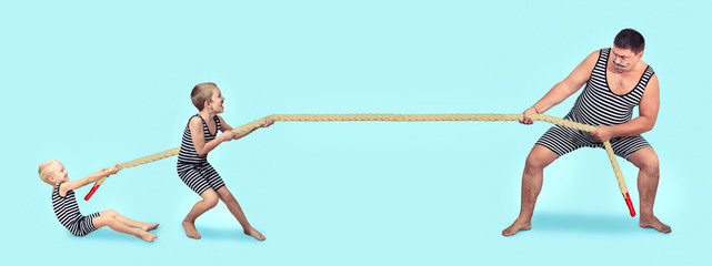 Family of strongman. Father and two sons in vintage costumes drag the rope. Family look.