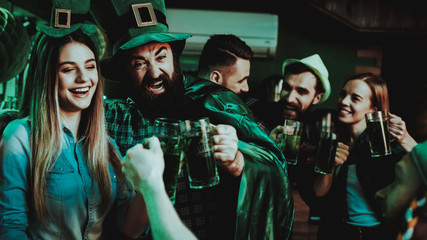 Man In Funny Hat Is Drinking Beer With A Girl.