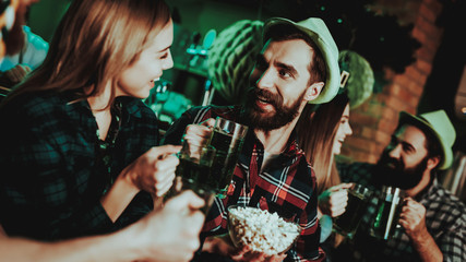 Man In Funny Hat Is Eating Popcorn With A Girl.