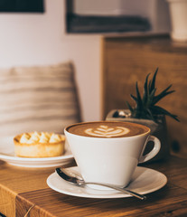 Cup of coffee and cake on a wooden table in a cafe