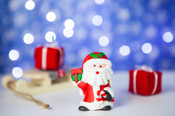 Gift boxes on sleigh and Santa on blue background