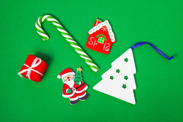 Christmas candy, white spruce and gift boxes on a green background, top view