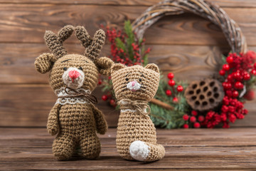 Wreath. Christmas winter frame on dark wooden background. Red elements Crochet Kraft Toys cat and deer