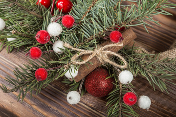 Wreath. Christmas winter frame on dark wooden background. Red elements