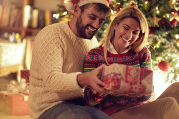 Christmas holiday - Cheerful man and woman with gift enjoying on Christmas eve.