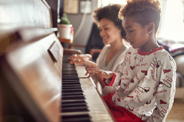 girl is playing on piano x-mas music. Concept Christmas, New Year, holiday, family happiness, childhood..