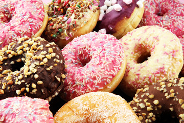 assorted donuts with chocolate frosted, pink glazed and sprinkles donuts