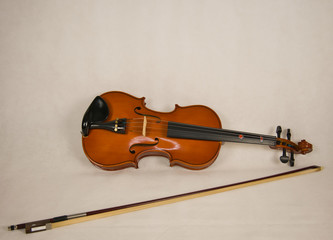 Braune Geige mit 4 Saiten und einen Geigenbogen