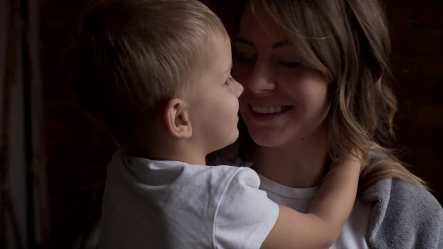 Boy whispering secret to mother's ear