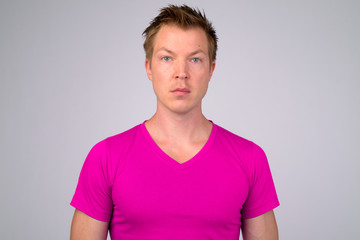 Fototapeta premium Face of young handsome man wearing purple shirt against white background