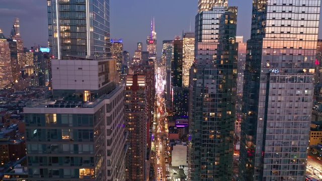 Aerial drone footage of New York skyline along 42nd street canyon, at dusk, with pull back camera motion