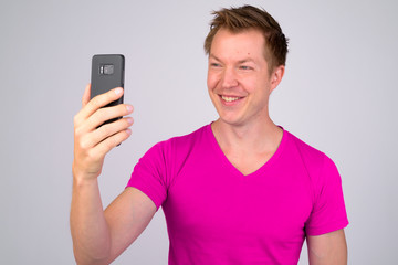 Happy young handsome man smiling while taking selfie
