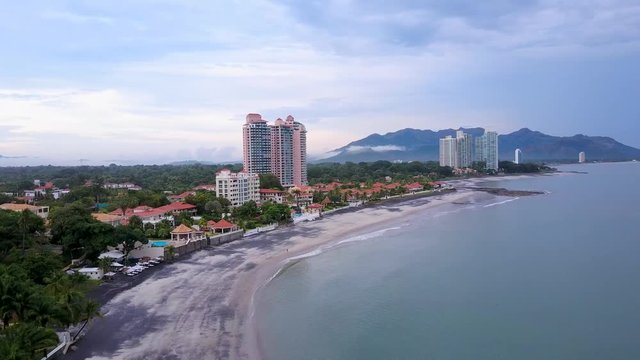 Aerial shot of beautiful villas, condos, sea, tropics, pools, mountains, beach.