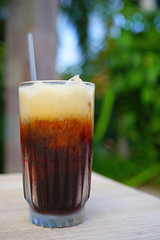 Glass of cold iced coffee with a straw