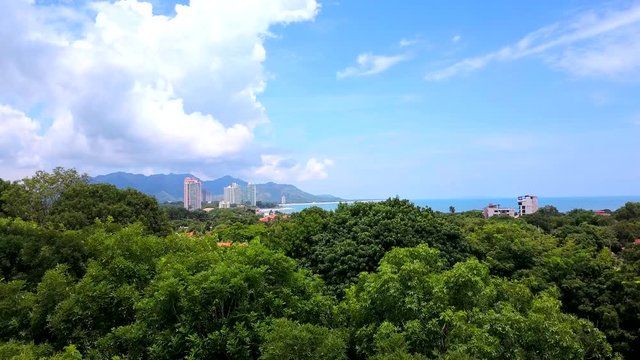 Aerial shot of beautiful tropical jungle, mountain, volcano, cloudy sky, villas.