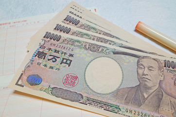 お金（一万円札）と通帳と印鑑