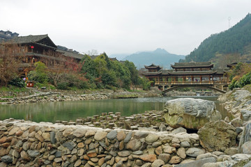 The Wooden Bridge of Qian Hu Miao Zai Village in morning mist , Guizhou province China.