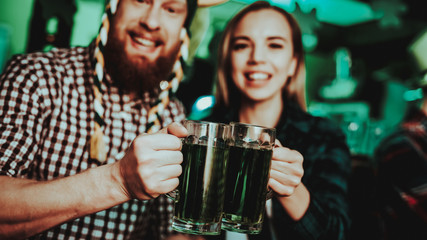 Man In Funny Hat Is Drinking Beer With A Girl.